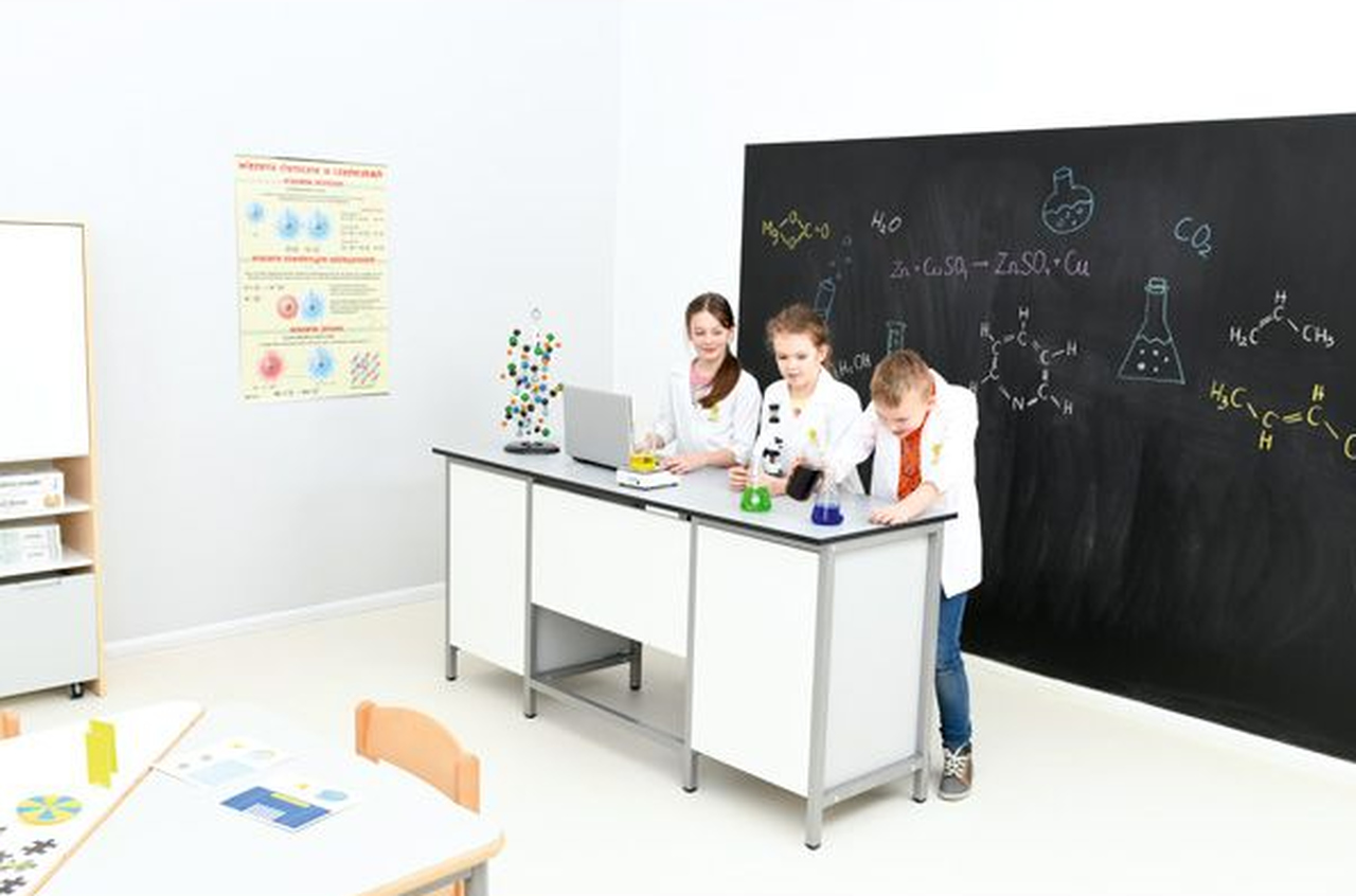 Dzieci na lekcji chemii wykonujące eksperymenty w klasie z wyposażeniem kupionym w ramach rezerwy oświatowej